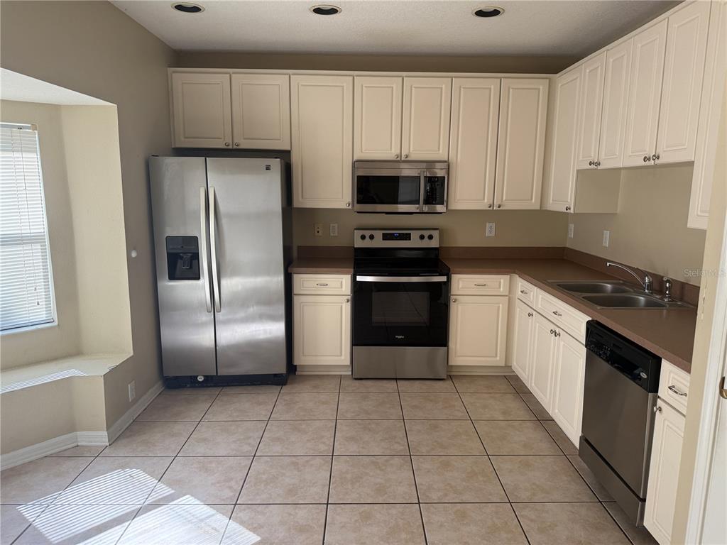 6509 Bridgecrest Drive Lithia, FL 33547 - Photo 4 of 15 a kitchen with stainless steel appliances granite countertop a refrigerator a stove a sink and white cabinets