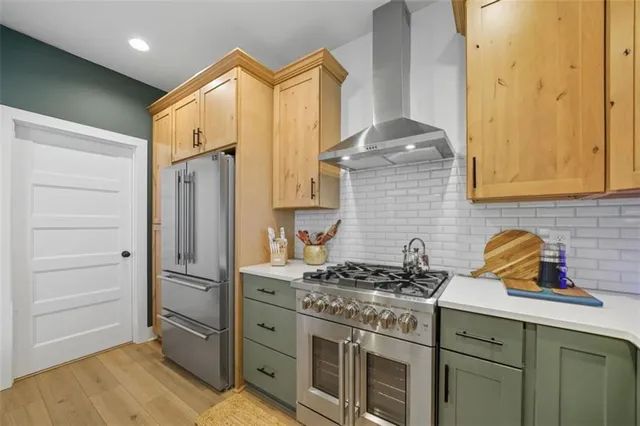a kitchen with stainless steel appliances a stove a refrigerator and cabinets
