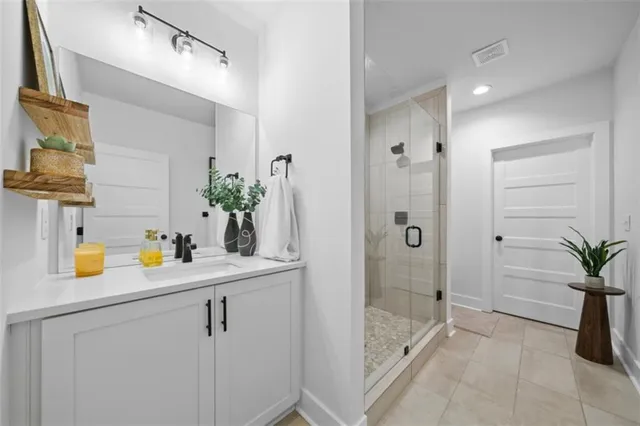 a bathroom with a granite countertop sink a mirror a vanity and shower