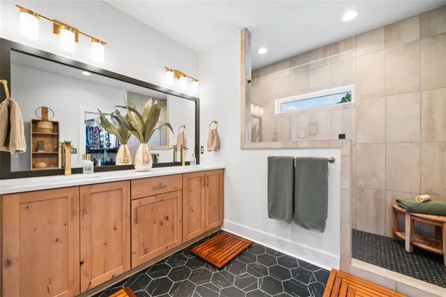 a spacious bathroom with a double vanity sink a mirror and a shower