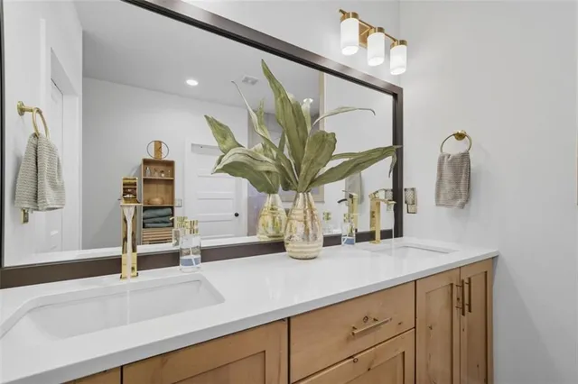 a bathroom with a sink a vanity and a large mirror