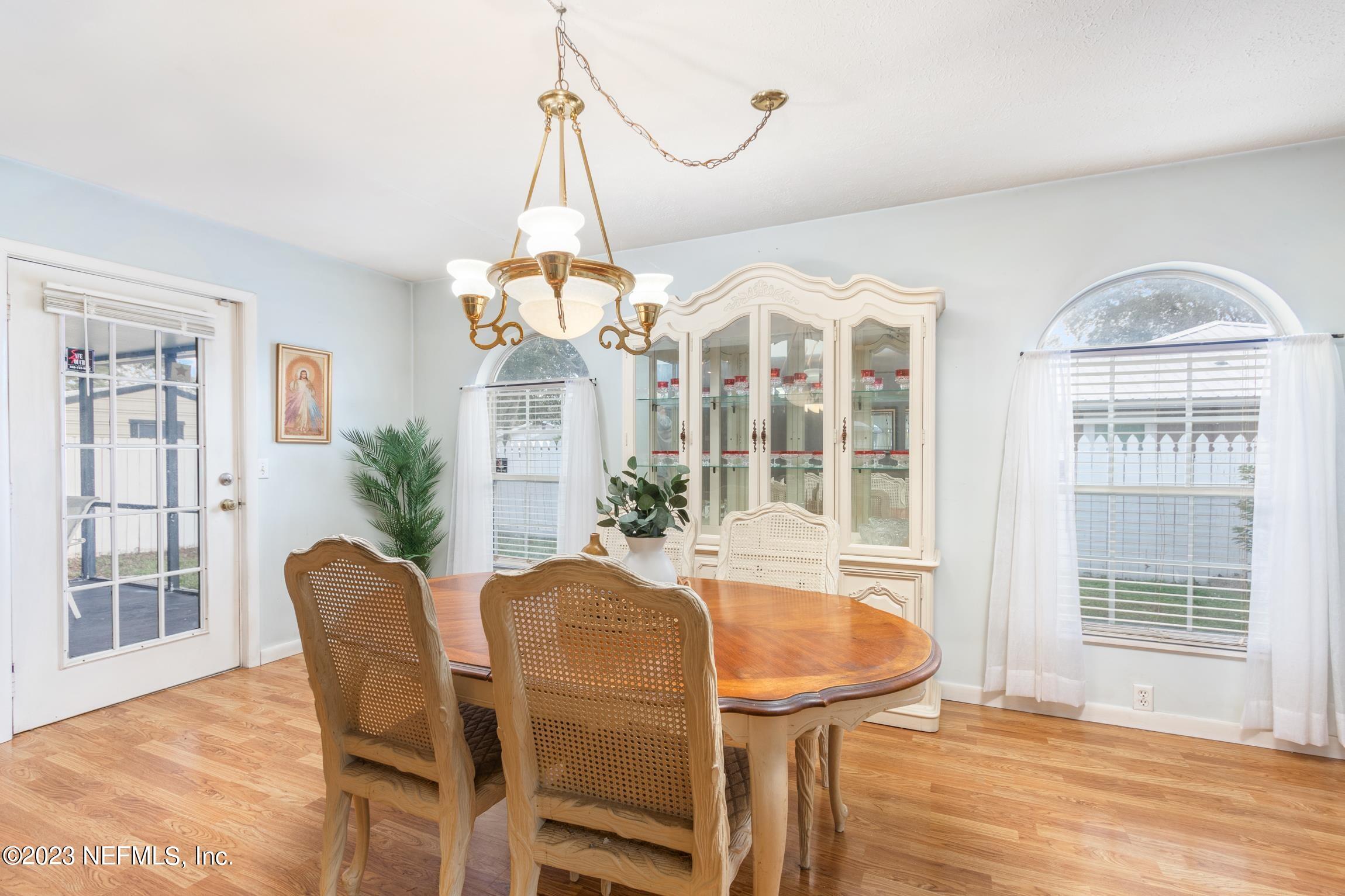 1131 Prince Road St. Augustine, FL 32086 - Photo 11 of 29 a dining room with furniture a chandelier and wooden floor