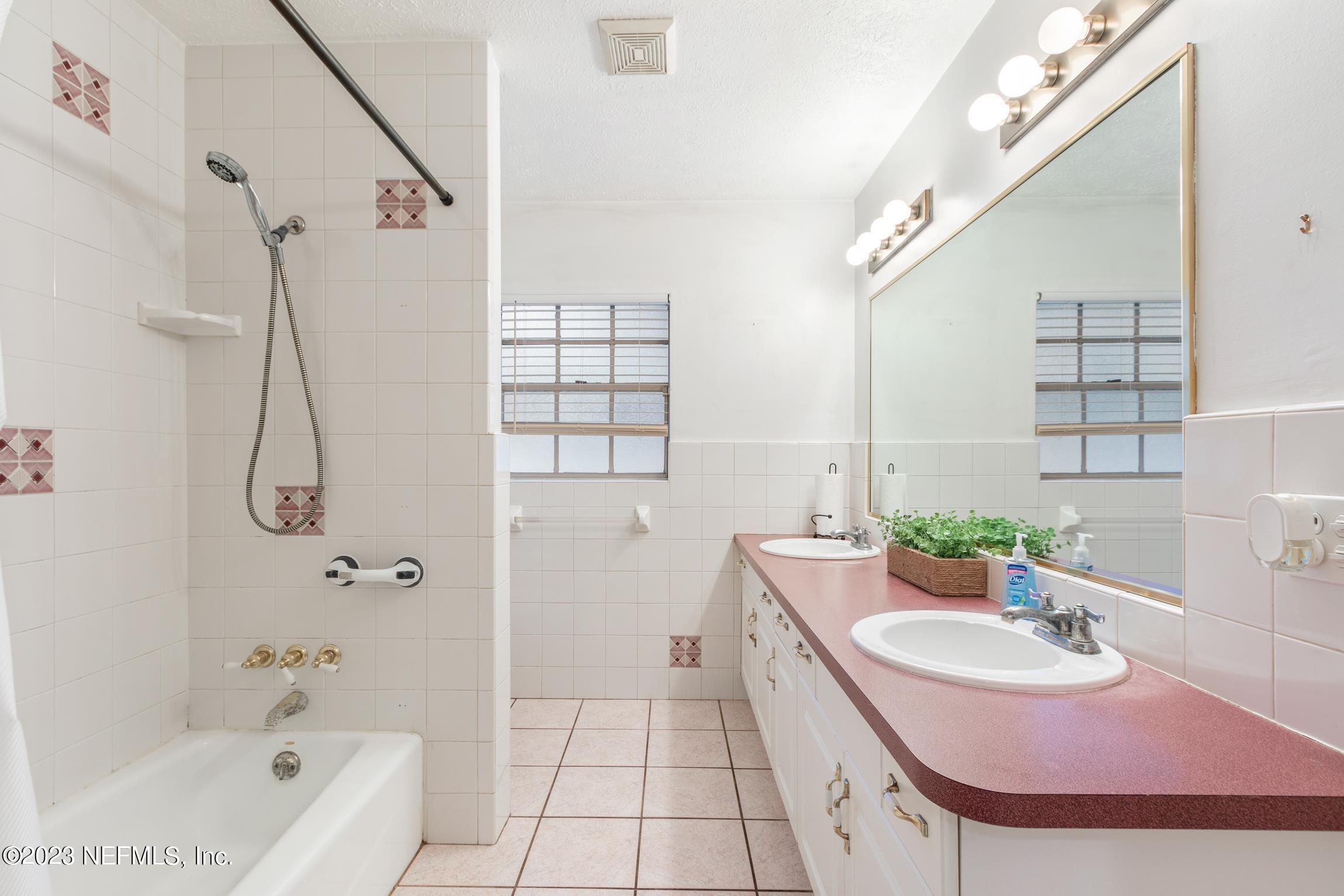 1131 Prince Road St. Augustine, FL 32086 - Photo 15 of 29 a bathroom with a granite countertop sink a mirror a bathtub and shower