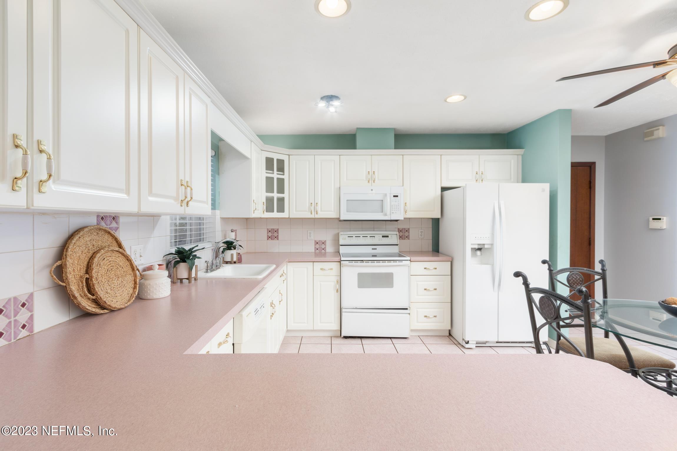 1131 Prince Road St. Augustine, FL 32086 - Photo 4 of 29 a kitchen with white cabinets and stainless steel appliances