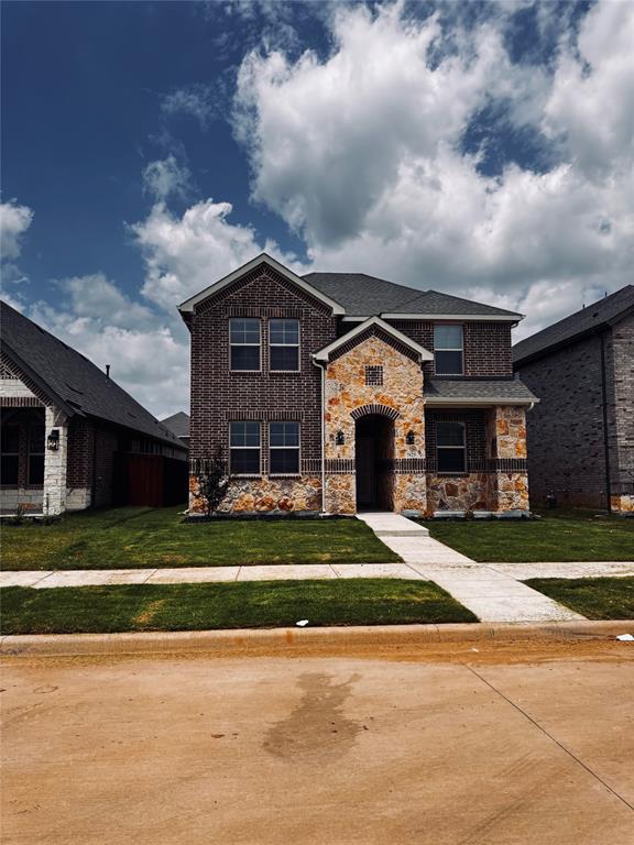 2625 Lewisville Road Celina, TX 75009 - Photo 1 of 7 Two-story residence featuring a brick and stone facade, arched entryway, and dark-paneled windows