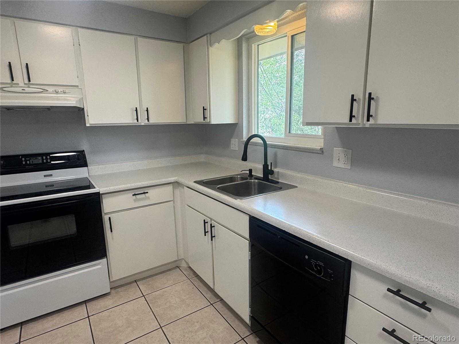 1273 Moore Street, Unit 1273 Denver, CO 80215 - Photo 6 of 13 a kitchen with a sink stove and cabinets