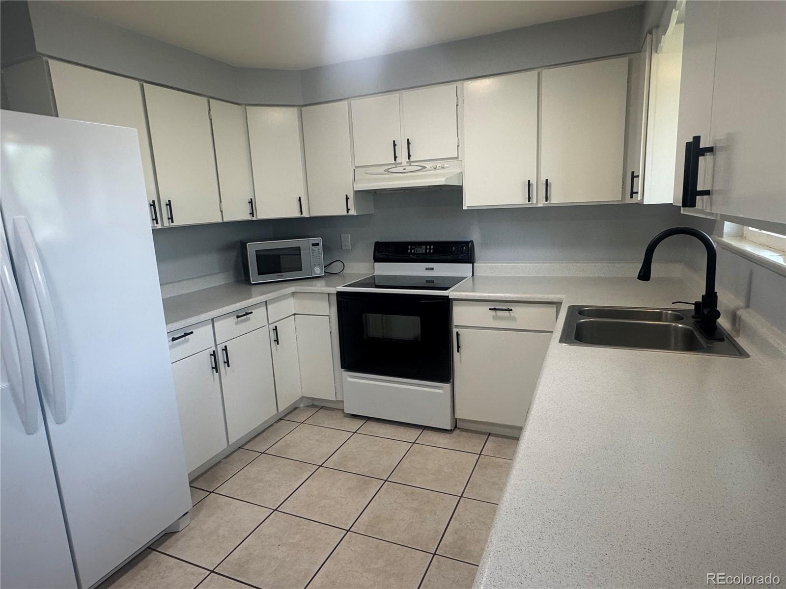 1273 Moore Street, Unit 1273 Denver, CO 80215 - Photo 8 of 13 a kitchen with white cabinets stainless steel appliances and sink