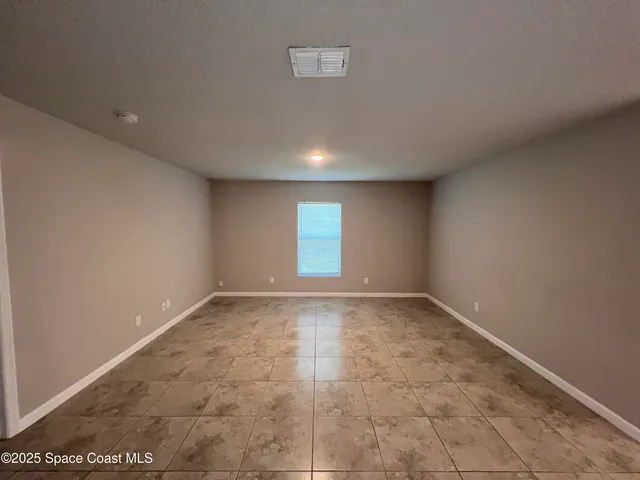 a view of an empty room and wooden floor