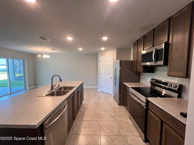 a view of a kitchen with a sink and chandelier
