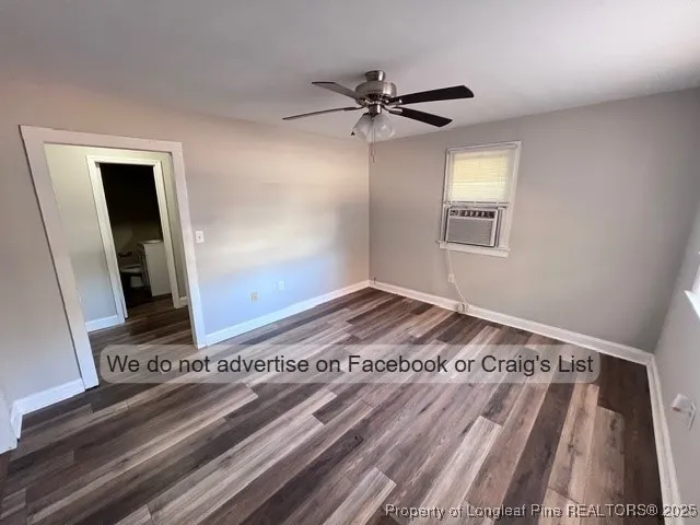 a view of a bedroom with a bed and wooden floor