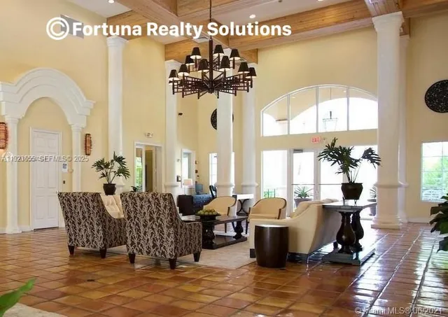 a living room with fireplace furniture and a potted plant