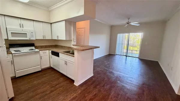 a kitchen with wooden floors and white appliances