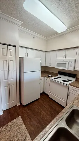 a kitchen with a refrigerator and a stove top oven