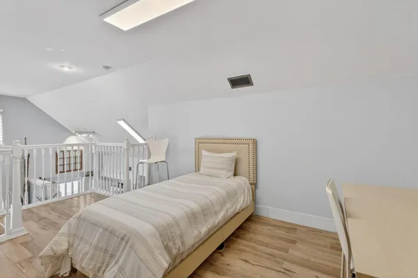 a bedroom with a bed and a wooden floor