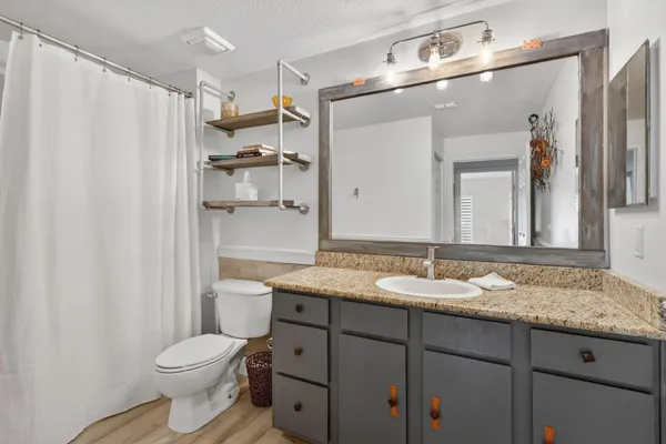 a bathroom with a granite countertop sink toilet and shower