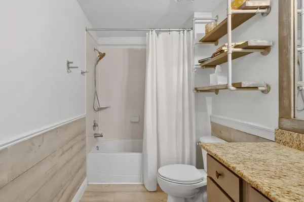 a bathroom with a granite countertop sink toilet and shower