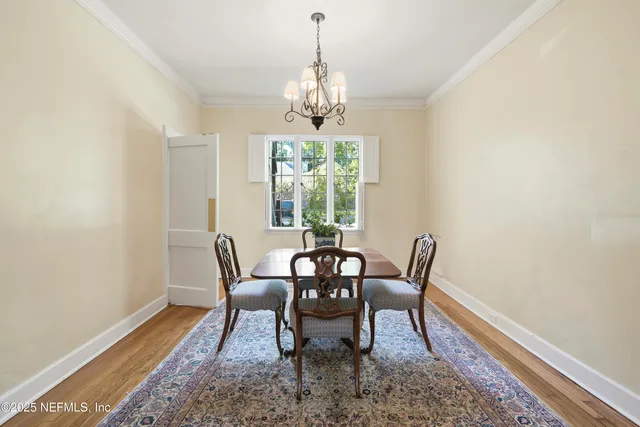 a dining room with furniture a chandelier and wooden floor