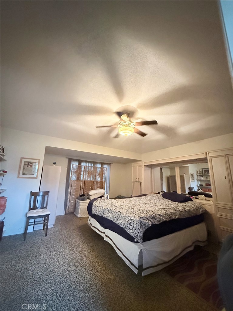 6380 North 5th Street Fresno, CA 93710 - Photo 11 of 31 a bedroom with a bed and a chandelier