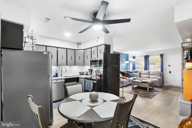 a kitchen with refrigerator cabinets dining table and chairs