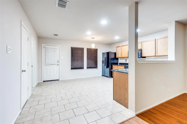 a view of a kitchen with refrigerator and kitchen