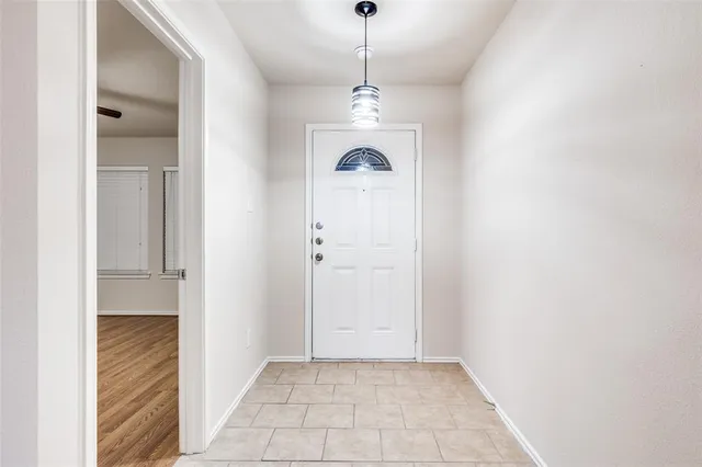 a view of a hallway with a chandelier and entryway