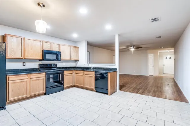 a large kitchen with granite countertop a stove a sink dishwasher and a refrigerator