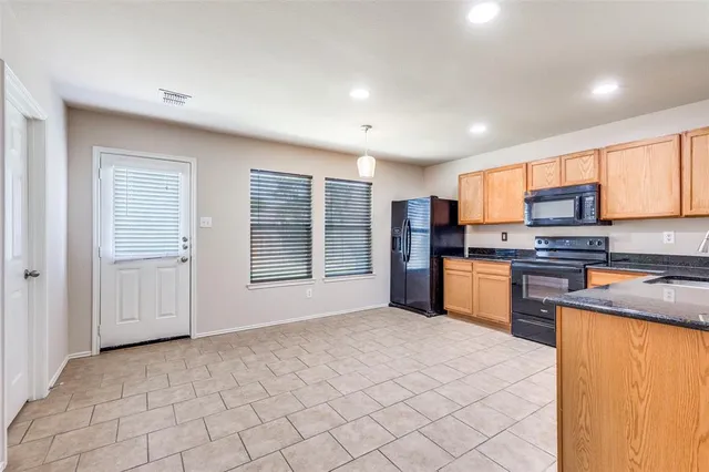 a kitchen with stainless steel appliances granite countertop a refrigerator sink and cabinets
