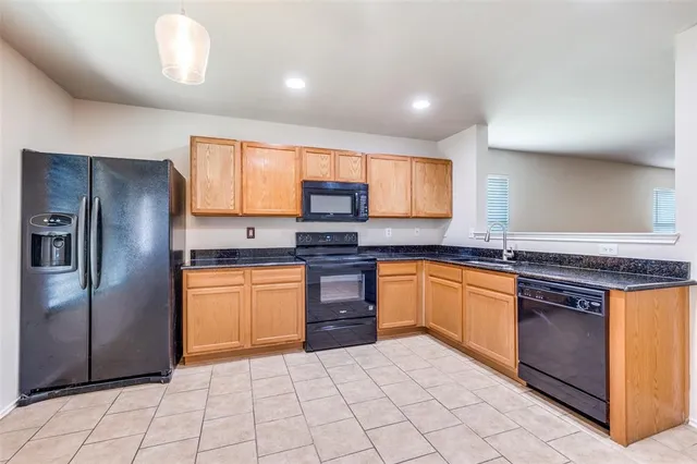 a kitchen with stainless steel appliances granite countertop a stove a sink and a refrigerator
