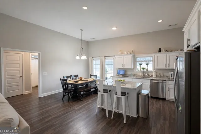 a kitchen with a table chairs refrigerator and cabinets