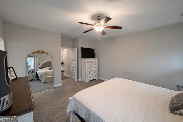 a bedroom with a large bed and a chandelier