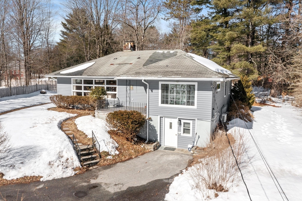 12 South Acton Road Stow, MA 01775 - Photo 1 of 41 a front view of a house with a yard covered with snow and trees