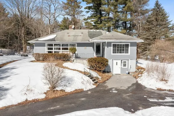 a front view of a house with a yard covered in snow