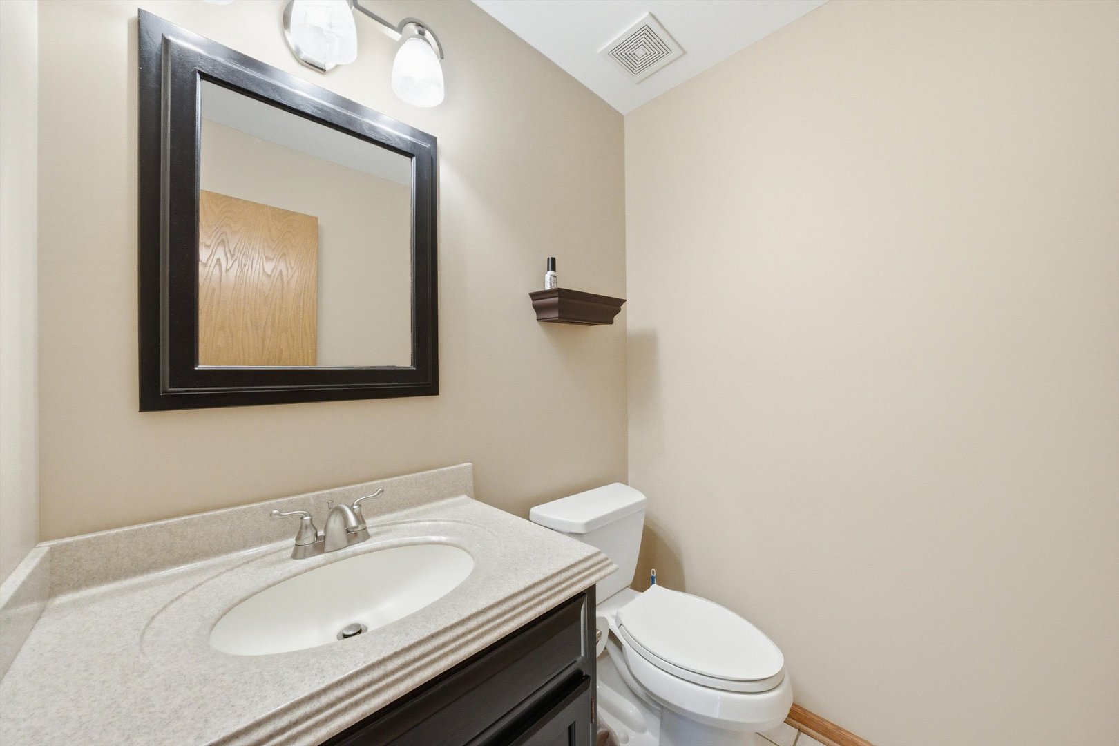 572 Bishops Gate New Lenox, IL 60451 - Photo 20 of 37 a bathroom with a toilet sink vanity and mirror