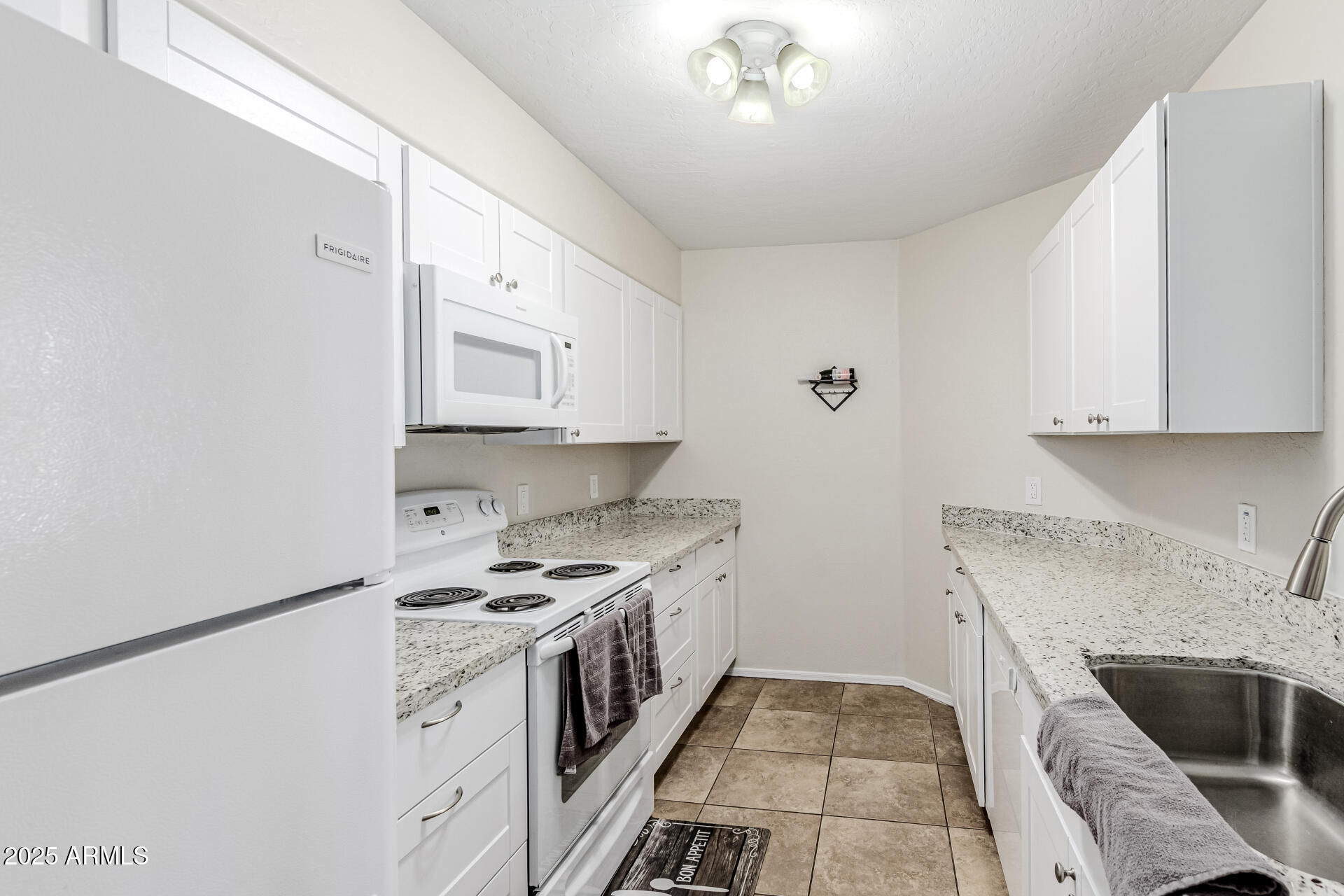 1287 North Alma School Road, Unit 156 Chandler, AZ 85224 - Photo 8 of 34 a kitchen with a stove sink and cabinets