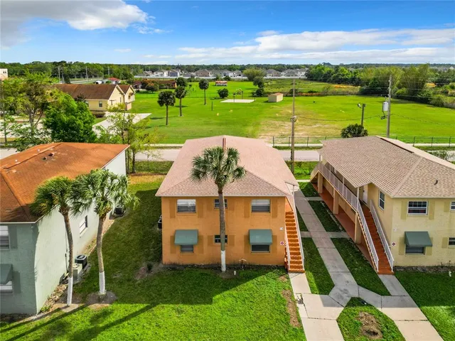 an aerial view of a house with outdoor space lake view and mountain view in back
