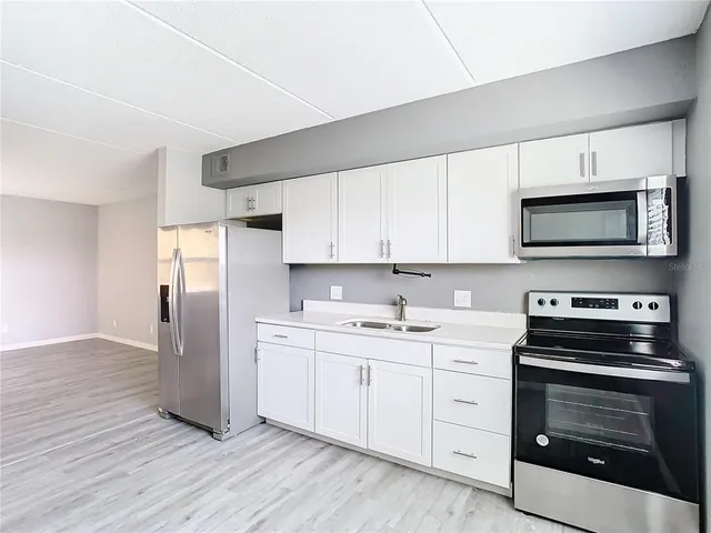 a kitchen with stainless steel appliances a stove microwave and cabinets