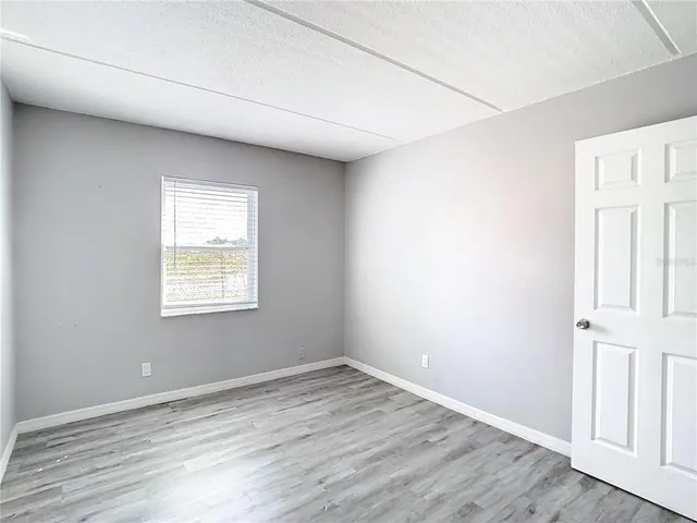 an empty room with wooden floor and window