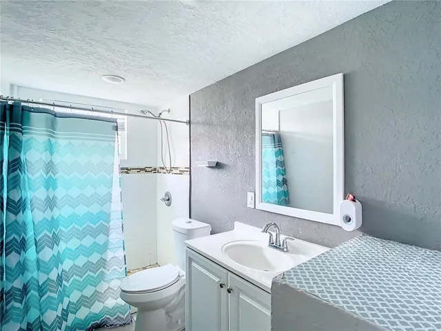 a bathroom with a granite countertop sink toilet and shower