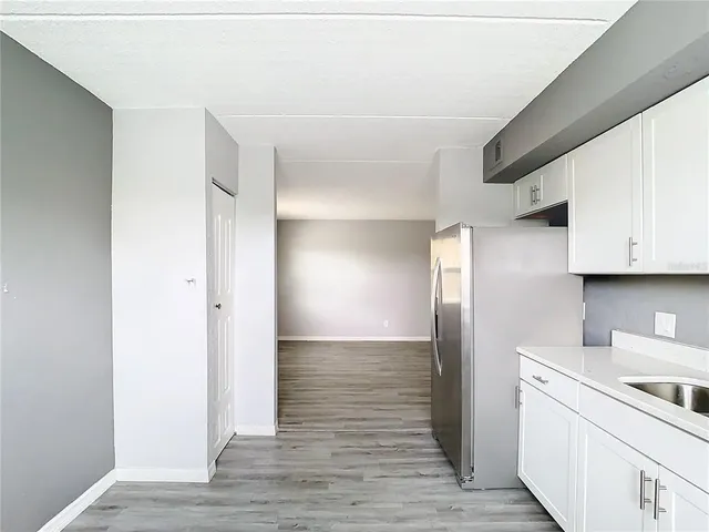 a view of a kitchen with a sink and refrigerator