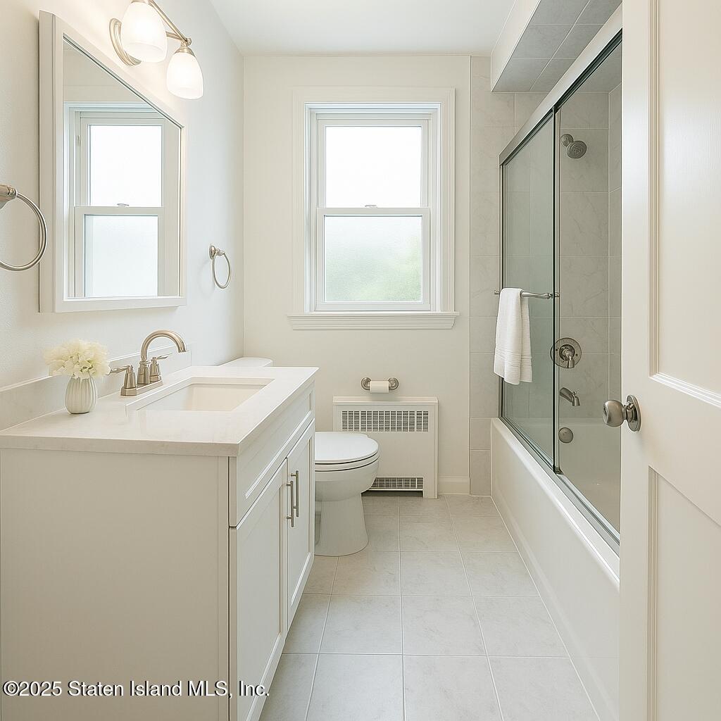186 Raritan Avenue Staten Island, NY 10304 - Photo 25 of 51 a bathroom with a double vanity sink toilet mirror and bathtub