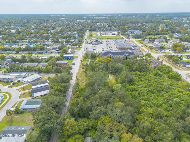 an aerial view of residential houses with outdoor space and trees
