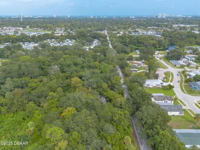 an aerial view of residential houses with outdoor space and trees