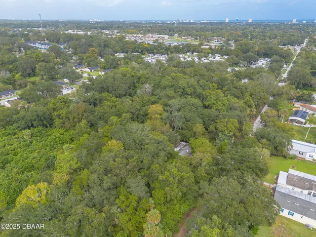 an aerial view of residential houses with outdoor space and trees