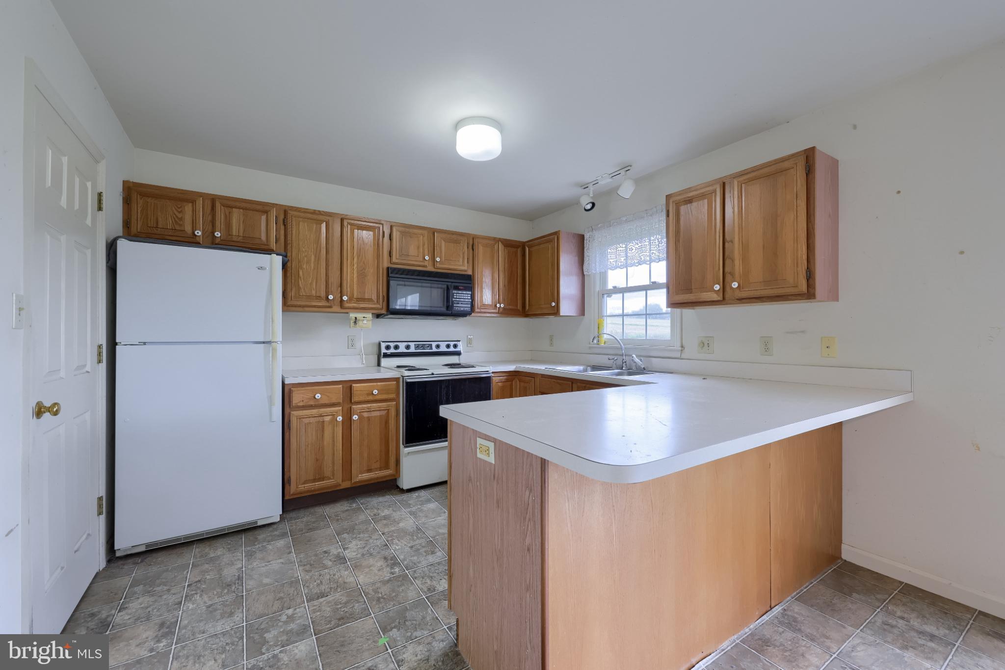 28 Brookview Drive Lititz, PA 17543 - Photo 18 of 31 a kitchen with a sink a stove a refrigerator a microwave oven and a window