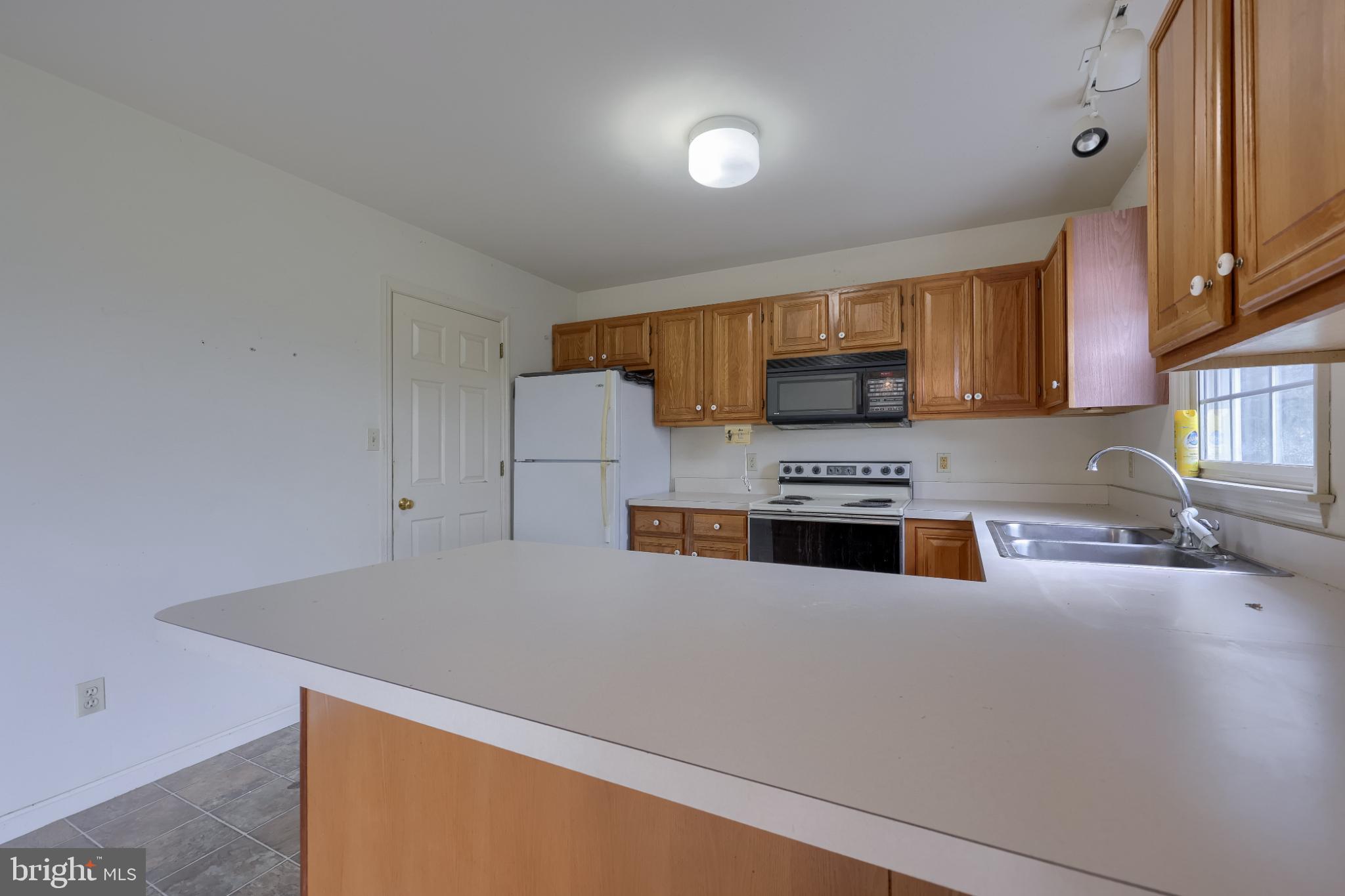 28 Brookview Drive Lititz, PA 17543 - Photo 20 of 31 a kitchen with granite countertop a stove a sink and a microwave