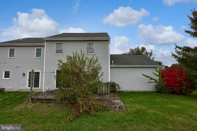 a backyard of a house with plants and barbeque oven