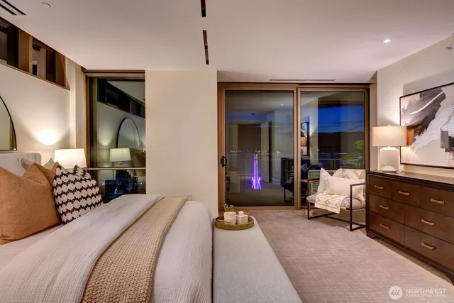 a bedroom with a bed and a lamp on dresser