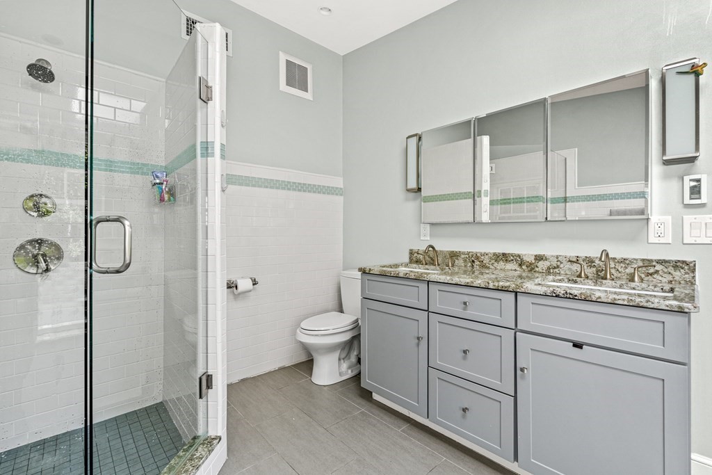 288 Mill Street Newton, MA 02460 - Photo 20 of 35 a bathroom with a granite countertop sink toilet and shower