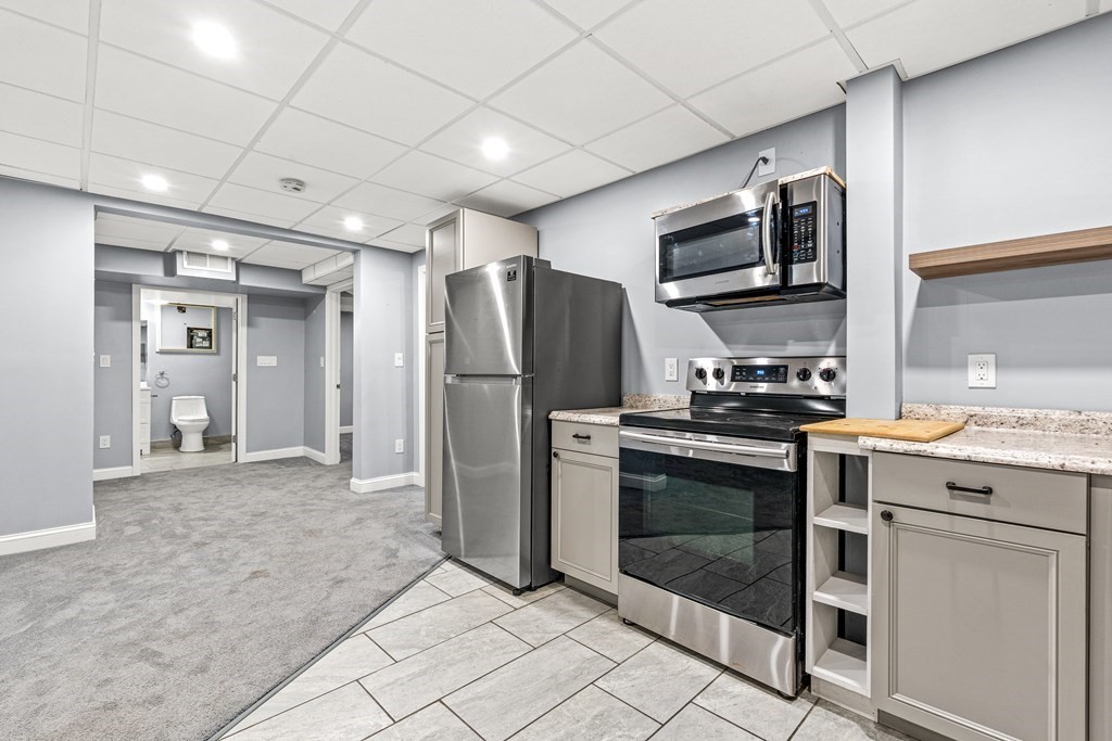 288 Mill Street Newton, MA 02460 - Photo 25 of 35 a kitchen with stainless steel appliances granite countertop a refrigerator and a stove top oven