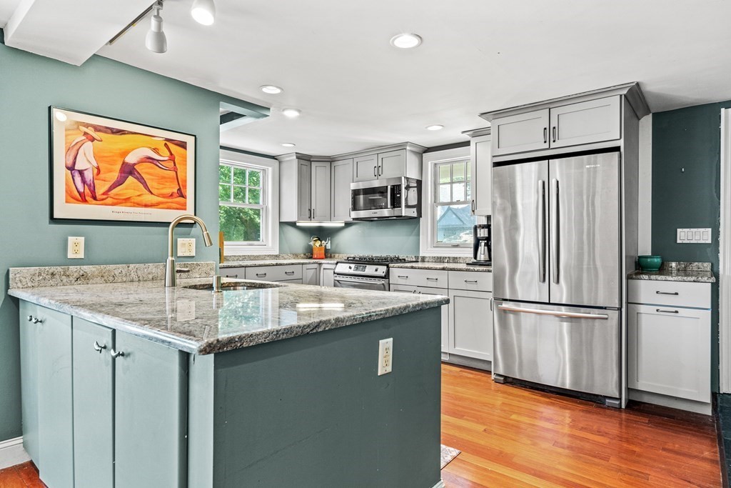 288 Mill Street Newton, MA 02460 - Photo 6 of 35 a kitchen with stainless steel appliances granite countertop a refrigerator a sink a stove a dining table and chairs